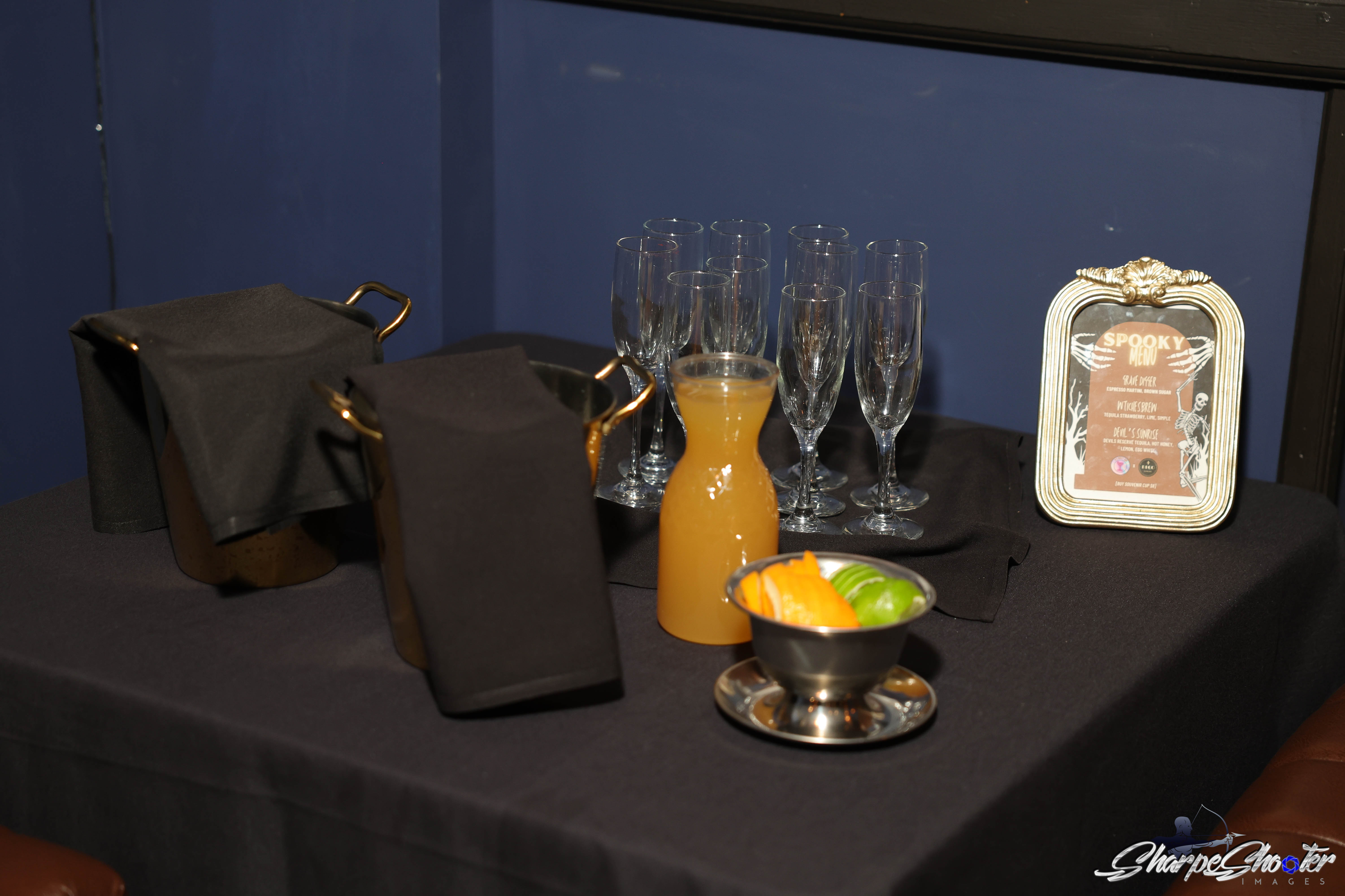 Champagne flutes, a carafe and citrus set out for service at Deco