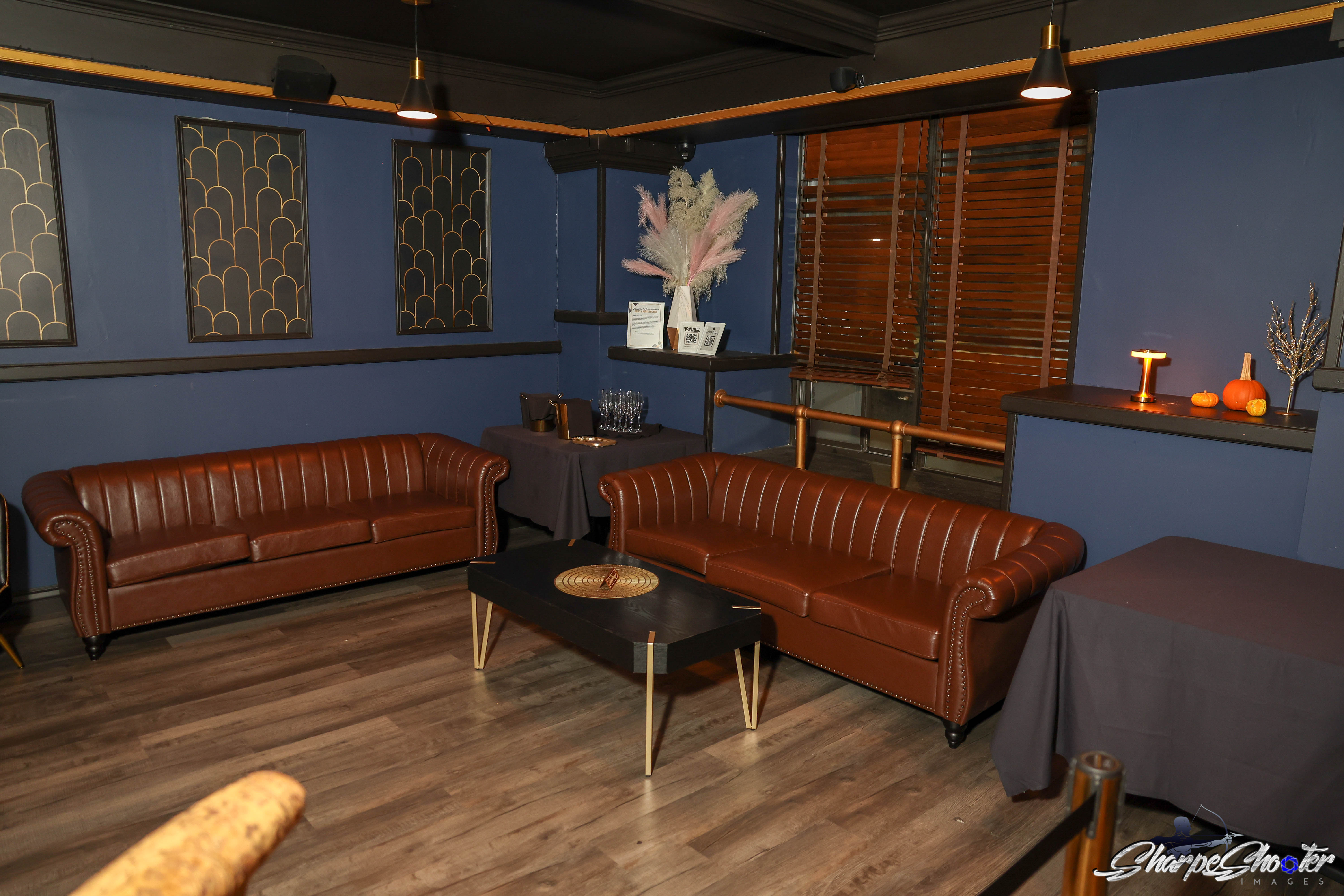 Leather Chesterfield sofas beneath gold Art Deco wall panels in the Deco lounge